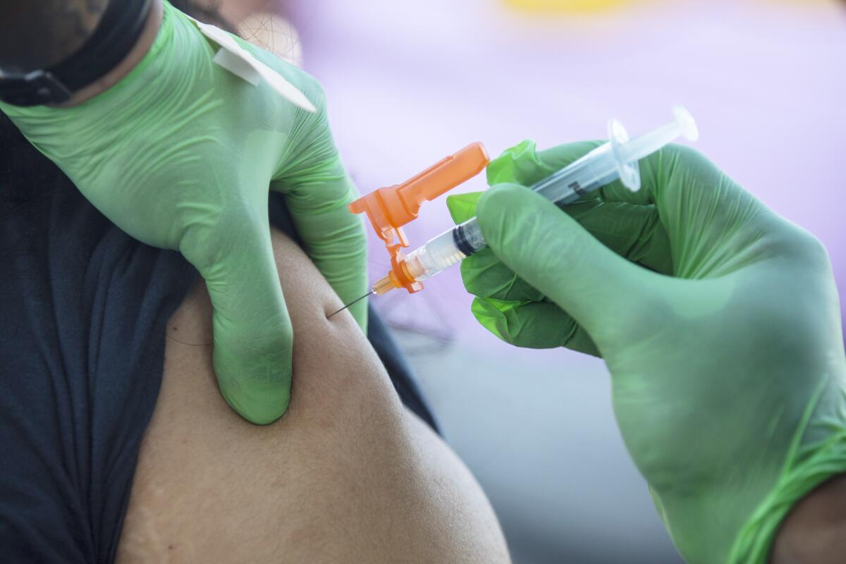 A person gets a COVID-19 vaccination shot. 