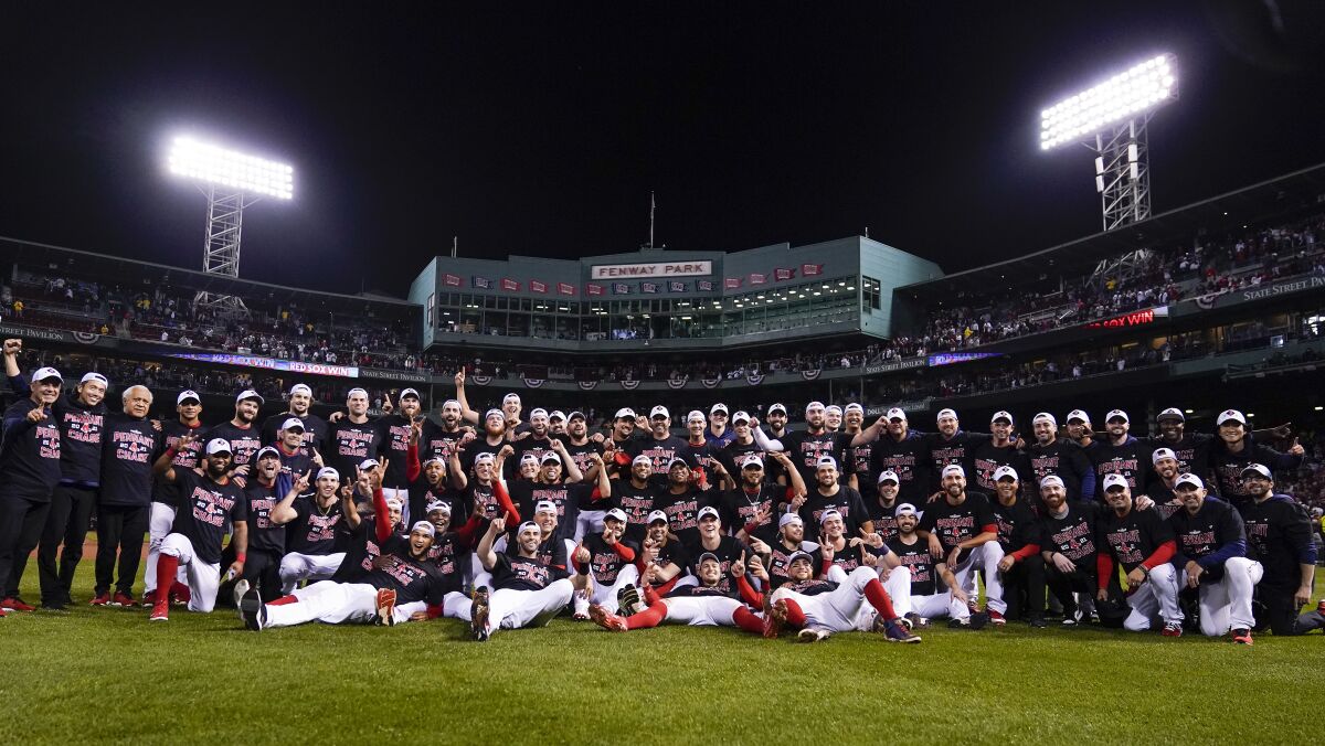 The Boston Red Sox pose for a photo on the field after defeating the Tampa Bay Rays 6-5 in Game 4 of a baseball American League Division Series, Monday, Oct. 11, 2021, in Boston. (AP Photo/Charles Krupa)
