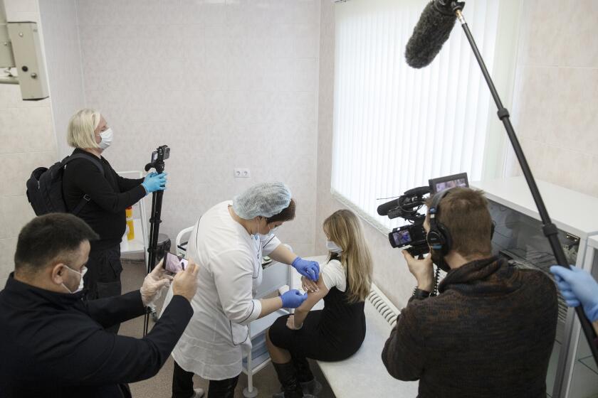 A Russian medical worker administers a shot of Russia's Sputnik V coronavirus vaccine in Moscow on Thursday, Dec. 10, 2020. While excitement and enthusiasm greeted the Western-developed coronavirus vaccine when it was rolled out, the Russian-made serum has received a mixed response, with reports of empty Moscow clinics in the first days of the rollout. (AP Photo/Pavel Golovkin)