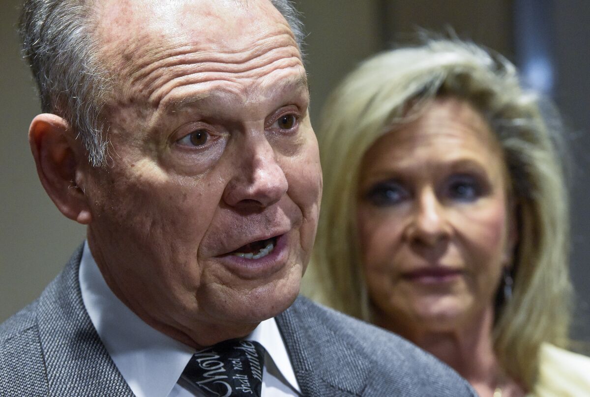 Roy Moore, left, and his wife Kayla Moore, right, pause to comment as they leave the courtroom at the Montgomery County Courthouse in Montgomery, Ala., on Wednesday, Feb. 2, 2022. A jury has found that no defamation occurred in dueling lawsuits between Moore and Leigh Corfman, the woman who accused him of molesting her when she was 14. Corfman came forward during the 2017 Senate race and said Moore sexually touched her in 1979 when he was an assistant district attorney in his 30s. (Mickey Welsh /The Montgomery Advertiser via AP)