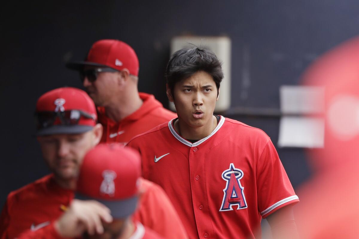 Shohei Ohtani walks in the dugout after grounding out during a spring training game against the Mariners on March 10.