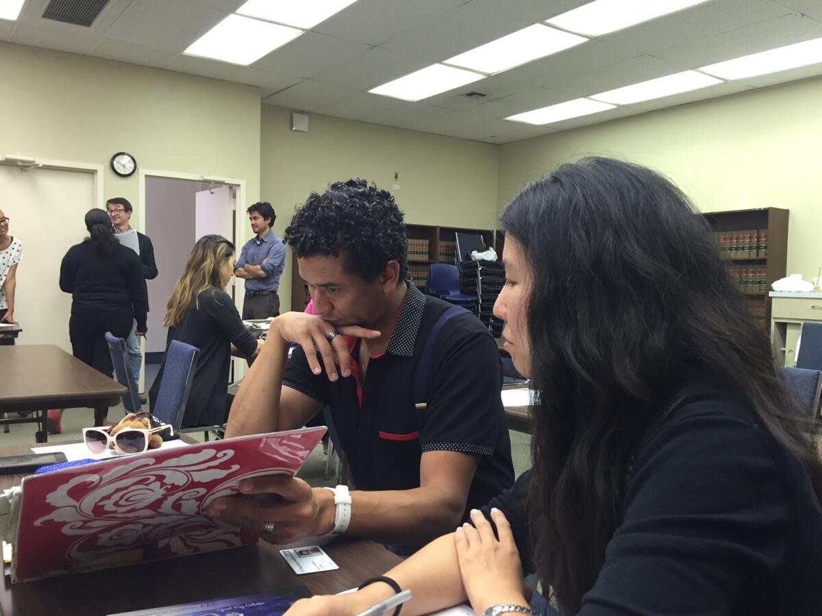 Alvaro Laborin, left, discusses his options with attorney Stephanie Lin of the Legal Aid Foundation of Los Angeles on Thursday after the closure of ITT Technical Institute's Torrance campus, where he had been studying cybersecurity.