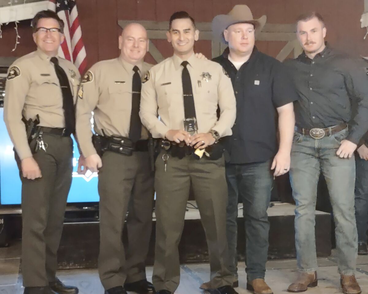 Ramona Sheriff’s Deputy Evan Maldonado, center, accepts his Law Enforcement Officer of the Year award with co-workers.