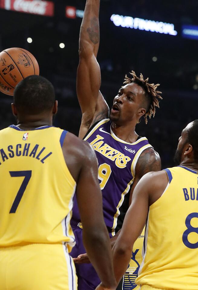 Lakers center Dwight Howard throws down a dunk over Golden State Warriors forward Eric Paschall and guard Alec Burks.