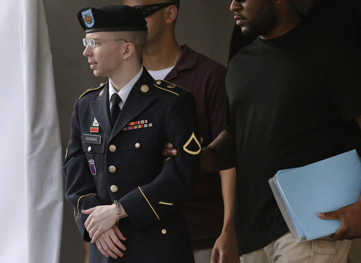 Army Pfc. Bradley Manning, left, is escorted to a security vehicle outside a courthouse in Fort Meade, Md., after leaving court.