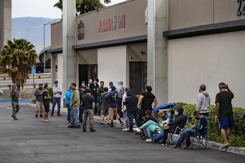 RIVERSIDE, CA - MARCH 31, 2020: Customers wait in line to buy guns at Warrior One Guns and Ammo during the coronavirus pandemic on March 31, 2020 in Riverside, California. (Gina Ferazzi/Los AngelesTimes)