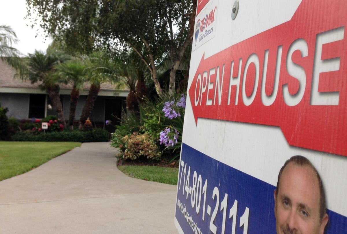 A for sale sign in front of a house. Southern California home sales and prices rose in July from a year earlier.