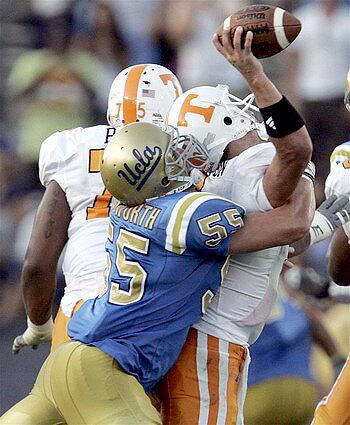 UCLA linebacker Korey Bosworth knocks the ball away from Tennessee quarterback Jonathan Crompton in the second quarter Monday.