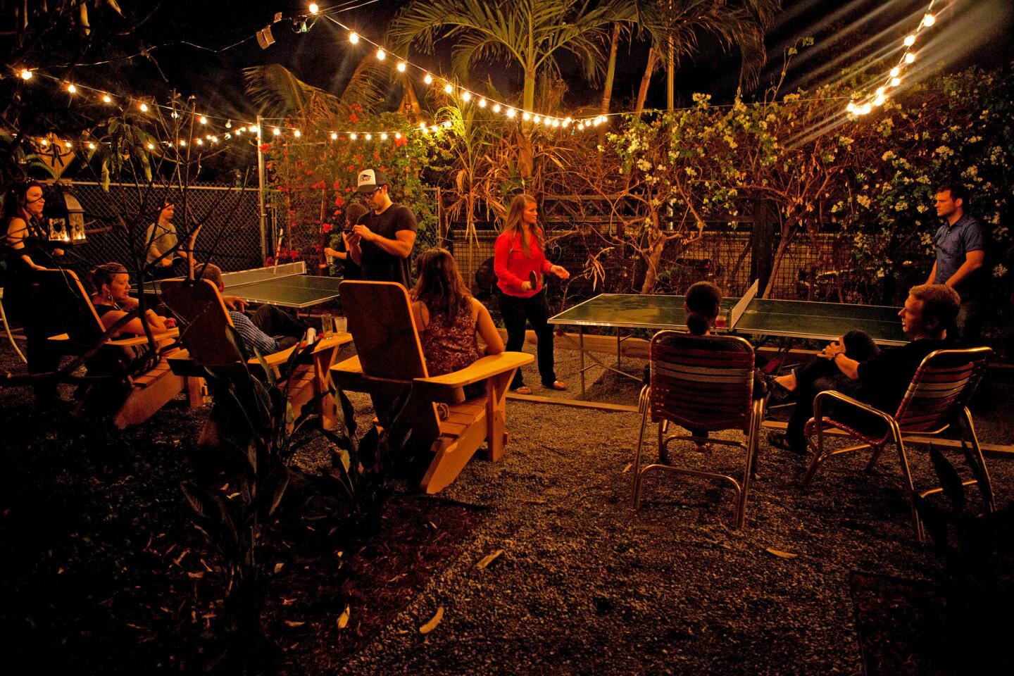 Patrons watch a pingpong game at the Broken Shaker Club, which is inside the Freehand Miami Hostel.