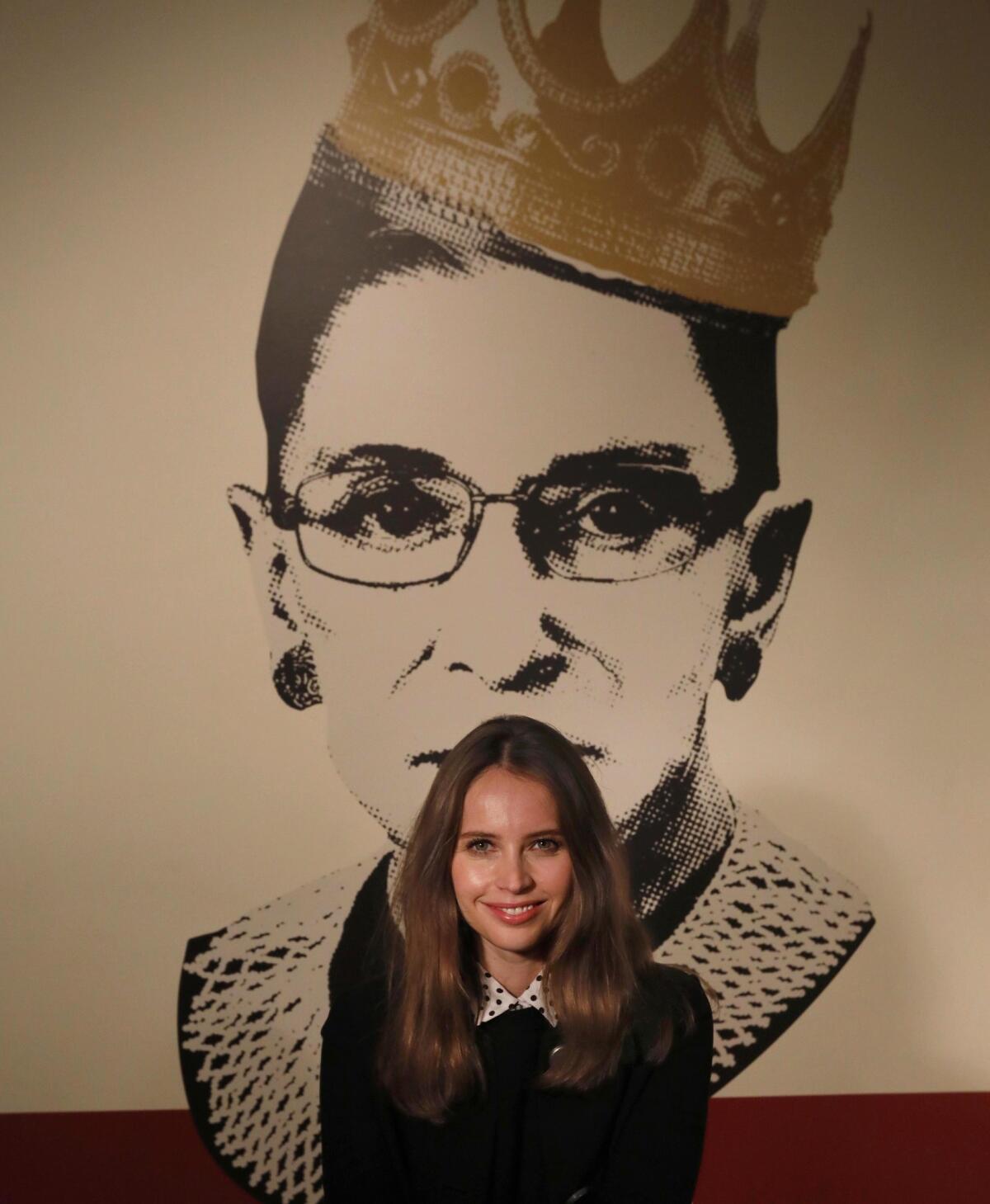 Academy Award-nominated actor Felicity Jones poses in front of an image of Justice Ruth Bader Ginsburg at the exhibit, "Notorious RBG, The Life and Times of Ruth Bader Ginsburg," at the Skirball Cultural Center in Los Angeles.