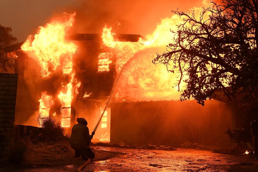 Wally Skalij??Los Angeles Times A FIREFIGHTER BATTLES a roaring house fire last year in Malibu, where residents must prepare for huge increases in fire insurance premiums regardless of the condition of their homes and properties.