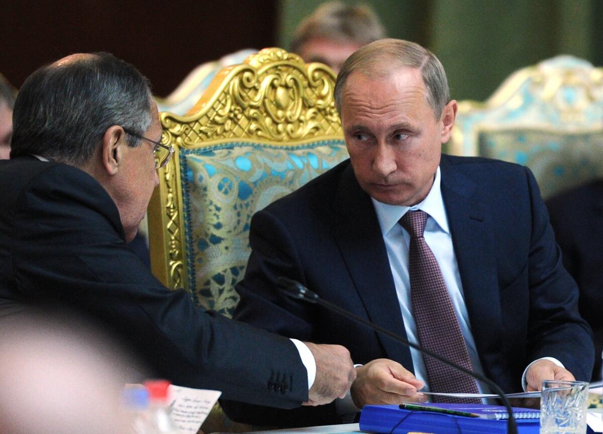 Russian President Vladimir Putin, right, confers with Foreign Minister Sergei Lavrov at a meeting of the Collective Security Treaty Organization in Dushanbe, Tajikistan, on Sept. 15, 2015.