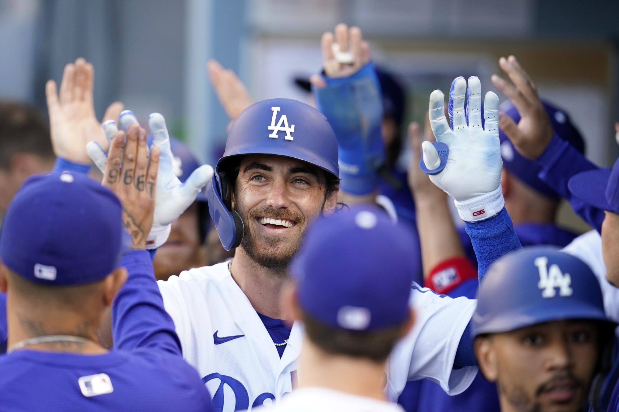 The Los Angeles Dodgers' Cody Bellinger, center, smiles in the dugout after hitting a grand slam 
