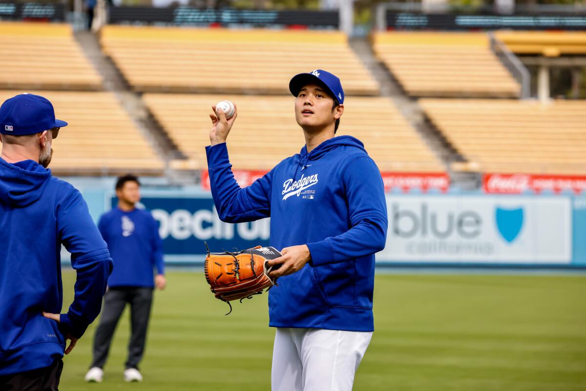 Shohei Ohtani throws a ball before the Dodgers faced the Angels in a spring training game.