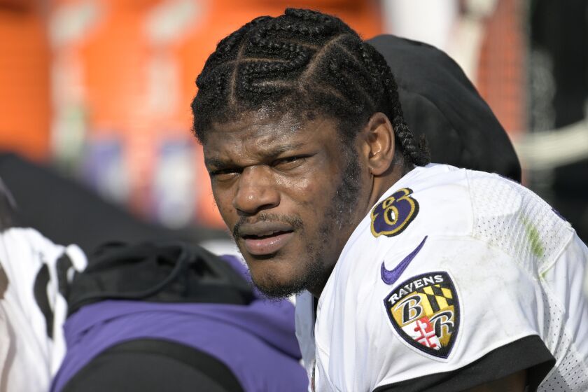 FILE - Baltimore Ravens quarterback Lamar Jackson (8) watches from the sideline during the first half of an NFL football game against the Jacksonville Jaguars, Sunday, Nov. 27, 2022, in Jacksonville, Fla. Lamar Jackson was again absent from practice during the portion open to reporters Wednesday, Jan. 11, 2023. The Baltimore star hasn't practiced since injuring his knee in a Dec. 4 win over Denver, and there was no sign of him Wednesday as the Ravens prepared for Sunday night's playoff opener at Cincinnati. Jackson missed the final five games of the regular season. (AP Photo/Phelan M. Ebenhack, File)