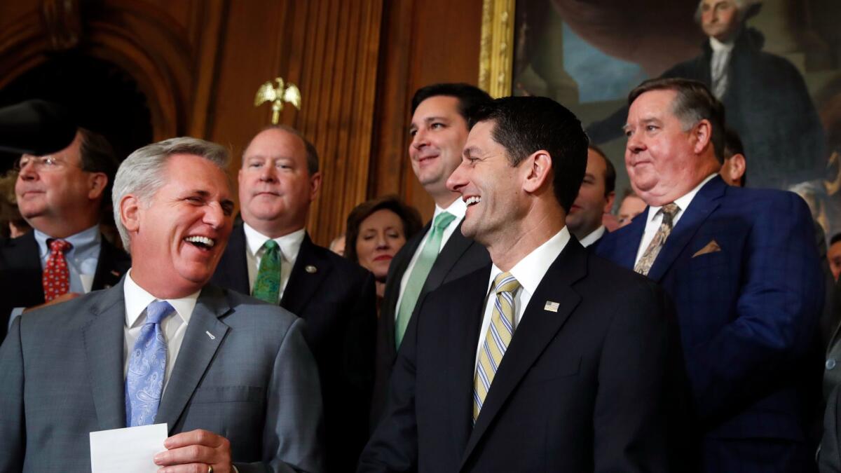 House Majority Leader Kevin McCarthy of Bakersfield, left, and House Speaker Paul D. Ryan talk with reporters about the GOP tax plan. Rep. Ken Calvert of Corona is at right behind Ryan.