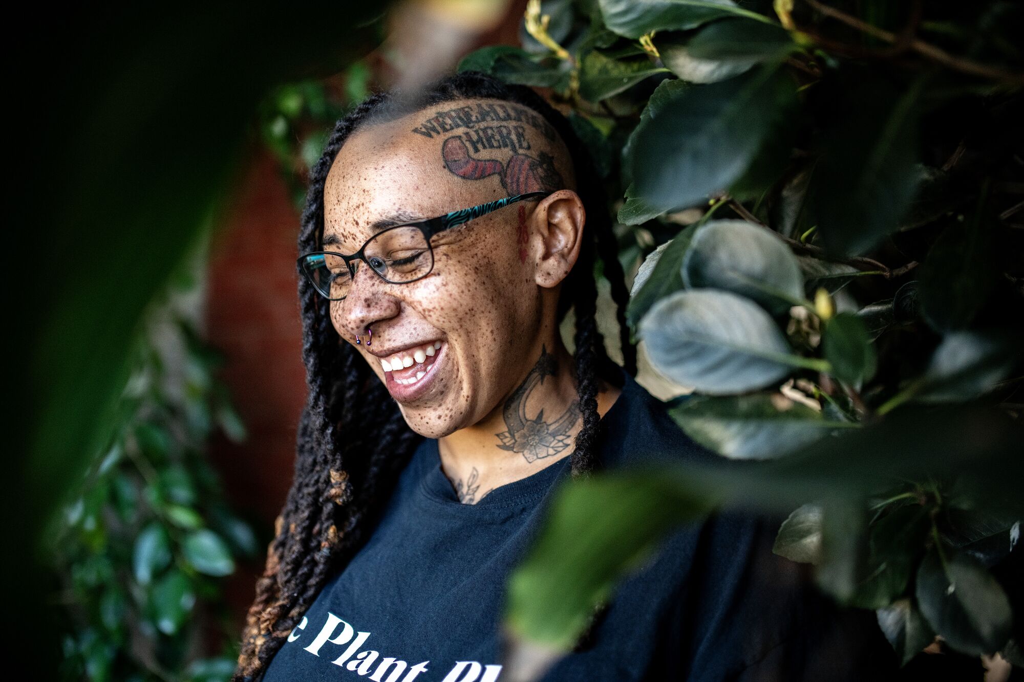 Taylor Lindsey smiles big, surrounded by greenery at her nursery.