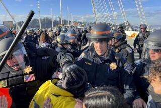 Police officers clear demonstrators blocking the San Francisco-Oakland Bay Bridge while protesting against the APEC summit on Thursday, Nov. 16, 2023, in San Francisco. (AP Photo/Noah Berger)