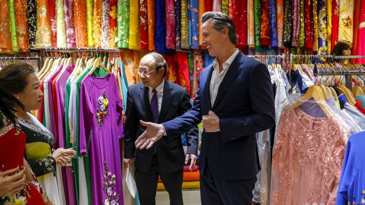 Lt. Gov. Gavin Newsom, the front-runner in the governor's race, visits a Westminster shop owned by Thanh Trang, left, during his weeklong bus tour of the state.