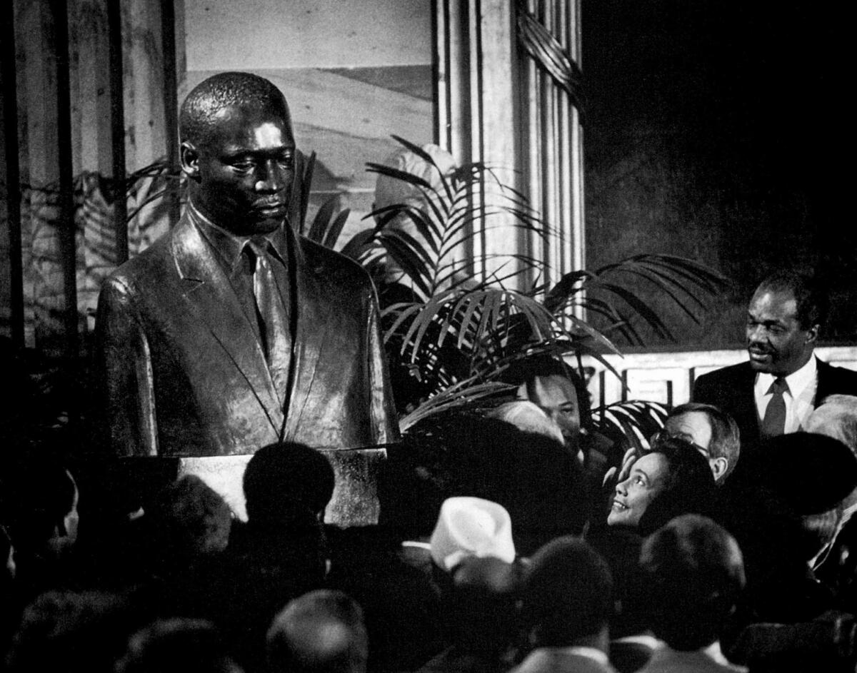 Jan. 16, 1987: Coretta Scott King, lower right, gazes up at a bronze bust of her late husband, the Rev. Martin Luther King Jr., after unveiling it in the Capitol in Washington, D.C. She called the statue a reminder "of our moral obligation to civil rights."
