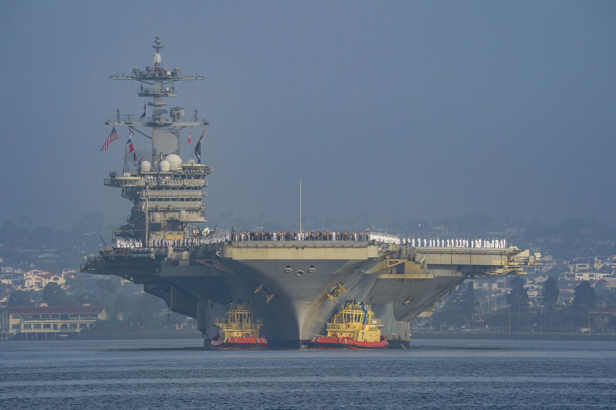The USS Abraham Lincoln (CVN 72) arrives San Diego with its crew of sailors manning the rail.