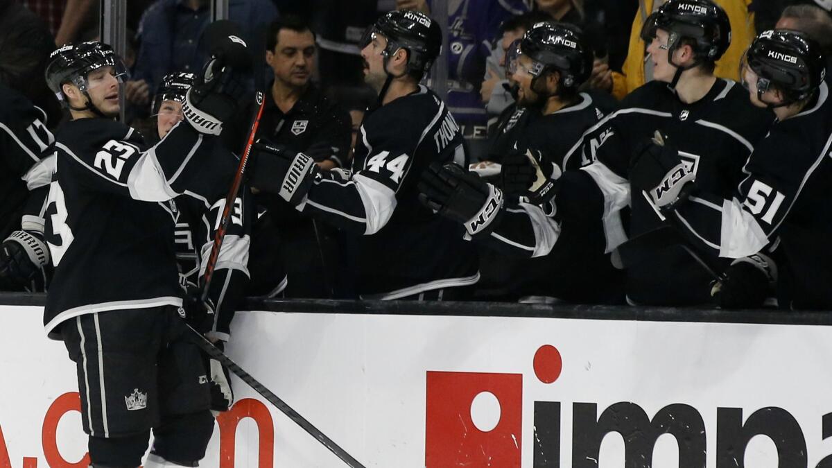 Kings right wing Dustin Brown, left, catches a hat thrown from the crowd after Brown scores his third goal of the game, for a hat trick, during the third period on Sunday.