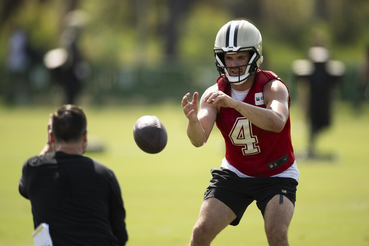 New Orleans Saints quarterback Derek Carr (4) catches the ball during NFL football training camp.