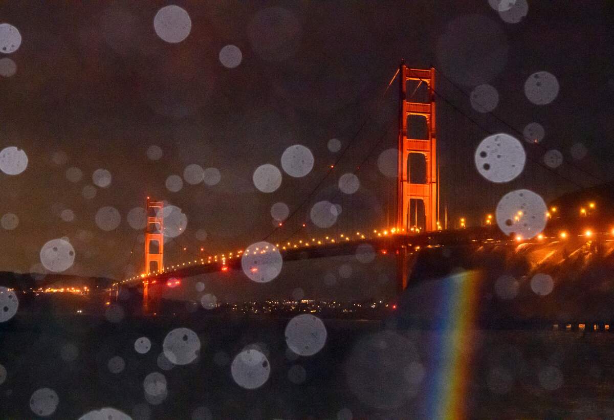 The Golden Gate Bridge is seen through  rain and splashing bay water 