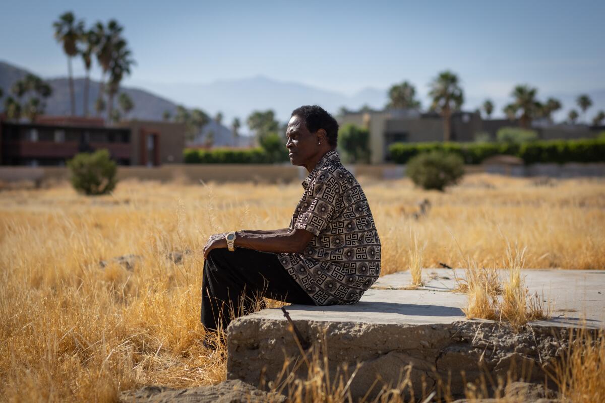 Alvin Taylor, a former resident of Palm Springs' Section 14, sits on the foundation of a destroyed home.  