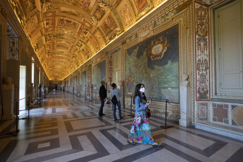 Visitors admire the Gallery of Maps as the Vatican Museum reopened, in Rome, Monday, June 1, 2020. The Vatican Museums reopened Monday to visitors after three months of shutdown following COVID-19 containment measures.
