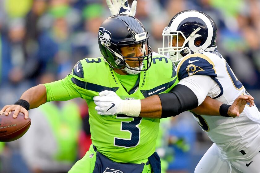 SEATTLE, WASHINGTON - OCTOBER 03: Russell Wilson #3 of the Seattle Seahawks is pressured by Aaron Donald #99 of the Los Angeles Rams during the first half of the game at CenturyLink Field on October 03, 2019 in Seattle, Washington. (Photo by Alika Jenner/Getty Images)