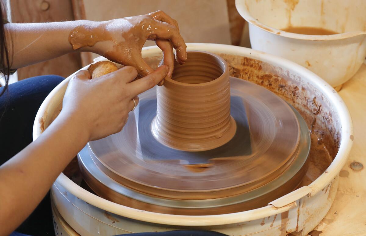 Sammy Chou works on a mug on her potter's wheel at the Lunch Time Ceramics studio in Costa Mesa.