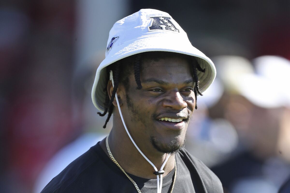 FILE - In this Jan. 25, 2020, file photo, AFC quarterback Lamar Jackson of the Baltimore Ravens smiles during Pro Bowl NFL football practice in Kissimmee, Fla. Lamar Jackson announced he will hold his annual “Funday with LJ” event in Florida amid the state's spike in coronavirus cases. Jackson's third annual event will be held Saturday and Sunday in his hometown of Pompano Beach, Florida, according to a flyer shared on his Instagram page Monday, July 6, 2020. Social gatherings in groups of more than 10 people is currently not allowed in Pompano Beach, according to the city’s website.(AP Photo/Gregory Payan, File)