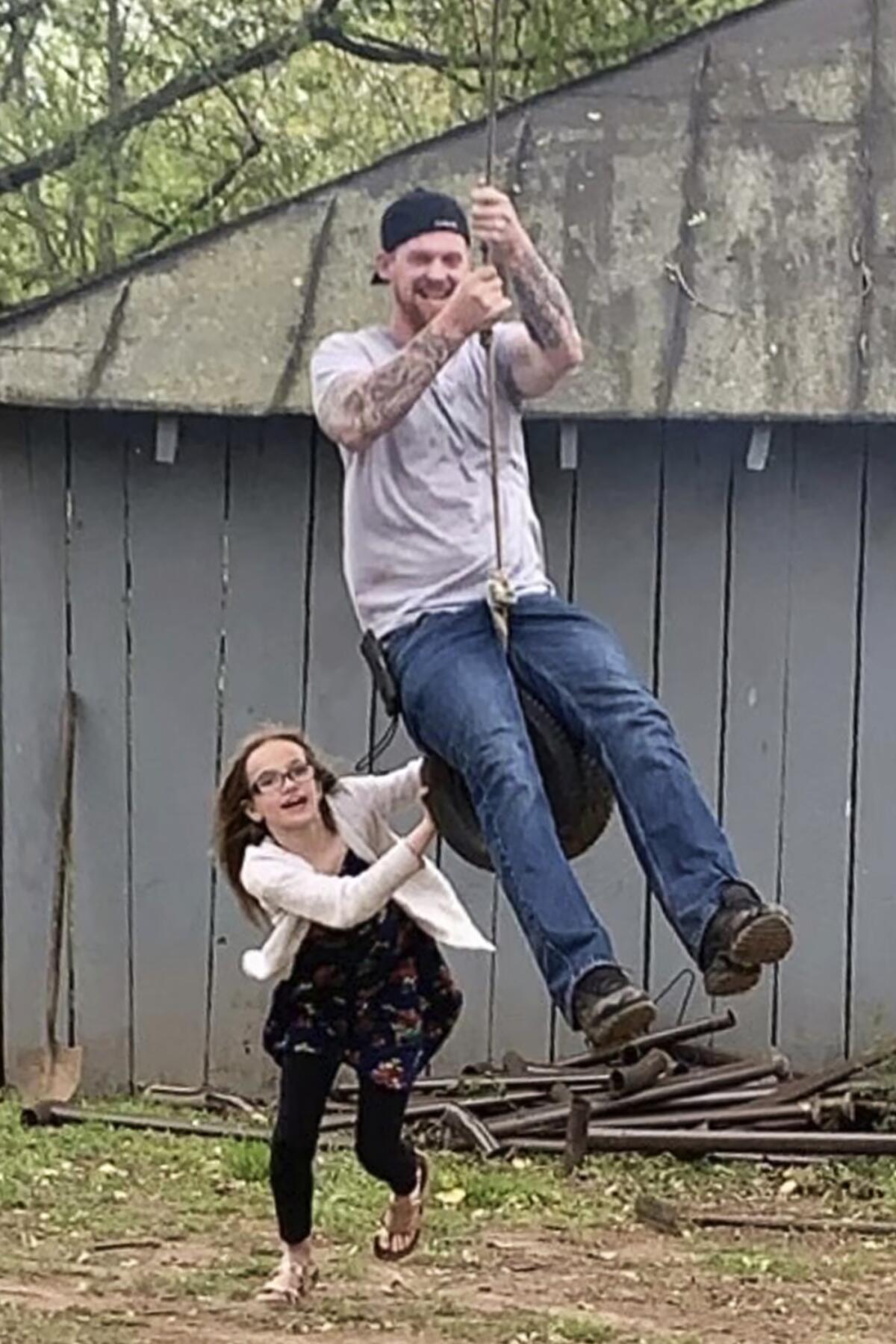 Matt Jones and his niece playing on a tire swing.