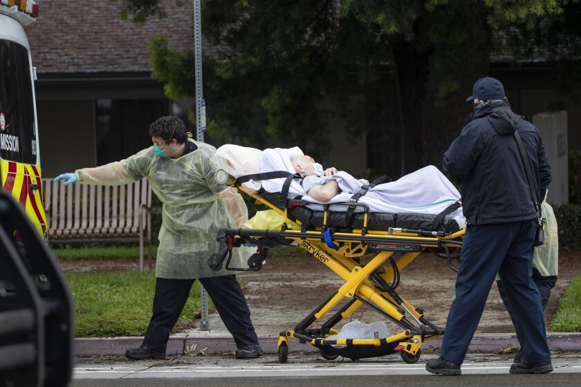 RIVERSIDE, CA- APRIL 8, 2020: Paramedics load Bernie Erwig, 84, into an ambulance while he was removed from Magnolia Rehabilitation and Nursing Center after 39 tested positive for coronavirus and nursing staff was not showing up to work for their own safety on April 8, 2020 in Riverside, California. All 84 residents were removed. Erwig tested positive for COVID-19 and was transferred to the county hospital in Moreno Valley, RUHS, where he spent 4 weeks recovering from the coronavirus. He is now home still recuperating. (Gina Ferazzi / Los Angeles Times)