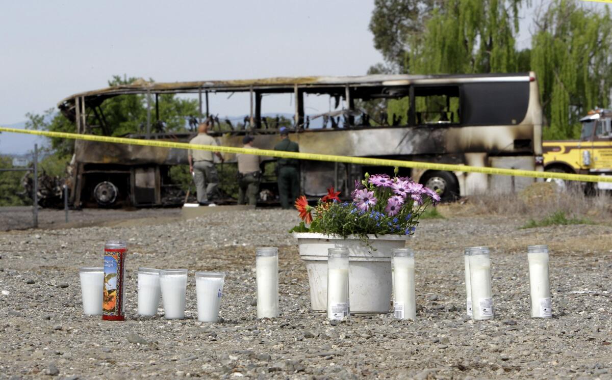Candles and flowers are displayed at a makeshift memorial for the victims of a multi-vehicle accident that included a tour bus and a FedEX truck on Interstate 5 in Orland, Calif.