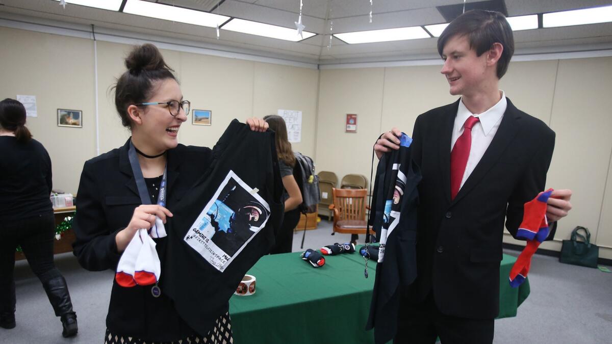 Students Jessi Diment and Colby Peterson open NASA gift bags brought by space industry grad student Alex Coultrup during the International Space Station program meeting at Brethren Christian High school in Huntington Beach.