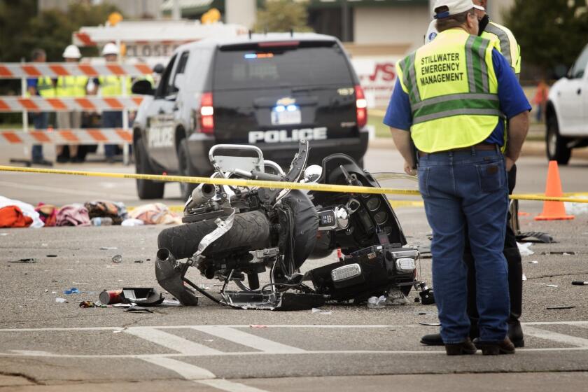 Emergency officials work at an accident scene after a driver crashed into a crowd of spectators during the Oklahoma State University homecoming parade in Stillwater, Okla.
