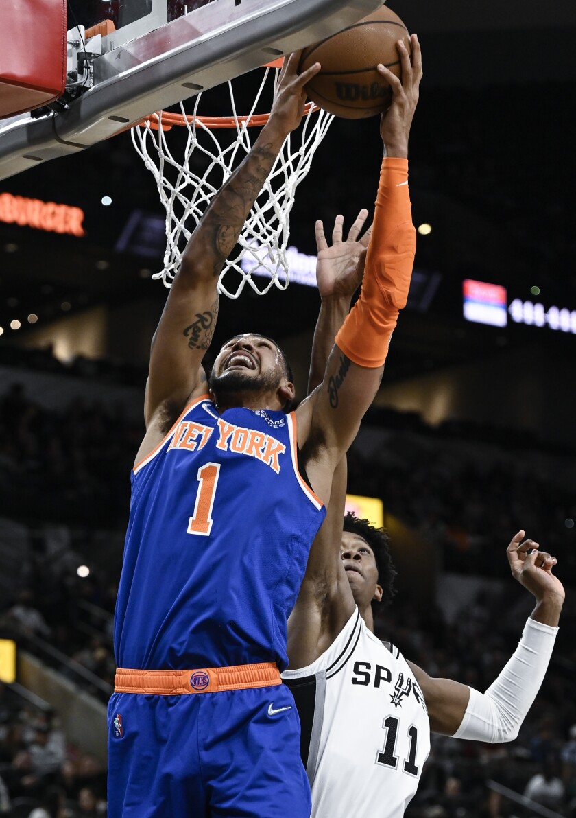 Obi Toppin (1), de los Knicks de Nueva York, busca la canasta mientras Josh Primo, de los Spurs de San Antonio, defiende en la primera mitad del partido de la NBA, en San Antonio, el martes 7 de diciembre de 2021. (AP Foto/Darren Abate)