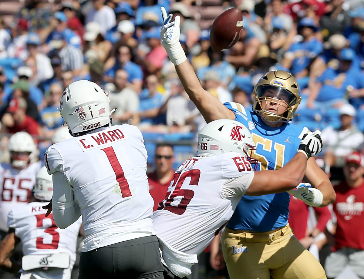 UCLA linebacker Jake Heimlicher bats down a pass by Washington State quarterback Cameron Ward.