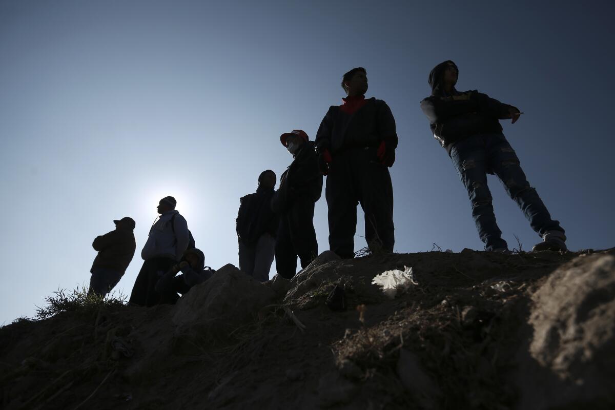 Migrantes están parados cerca de la frontera entre México y Estados Unidos en Ciudad Juárez