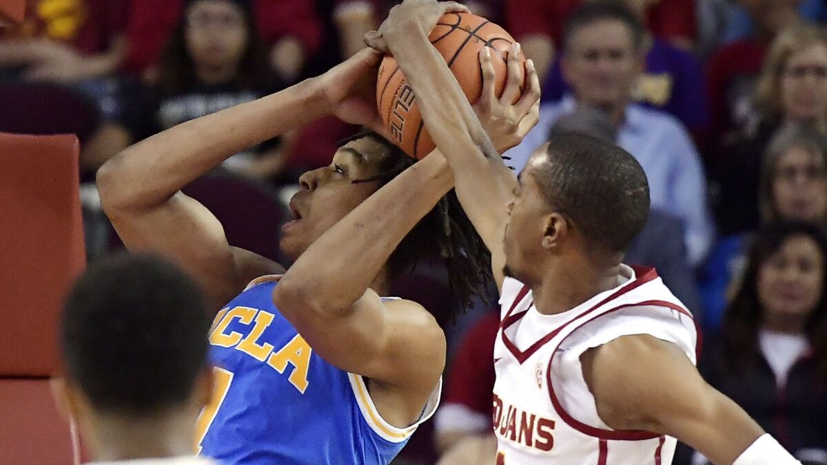 USC guard Shaqquan Aaron, right, blocks the shot of UCLA center Moses Brown during the first half on Saturday.