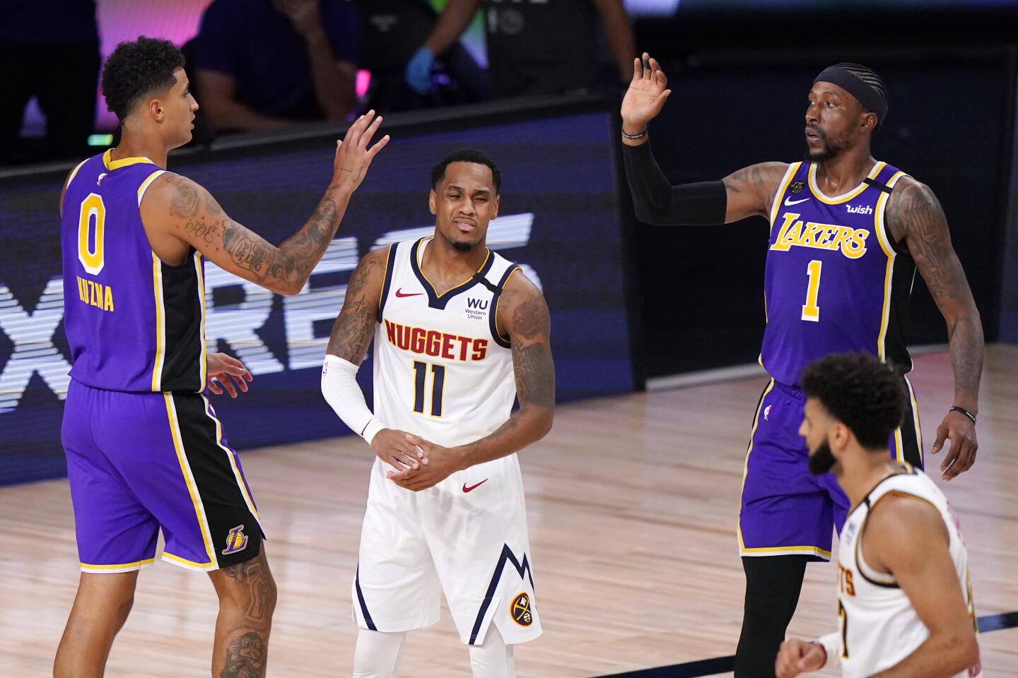 Lakers forward Kyle Kuzma (0) and guard Kentavious Caldwell-Pope (1) with Nuggets guard Monte Morris (11) during Game 5.