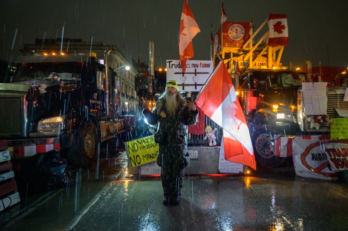 Canadian truck protestor standing in rain.