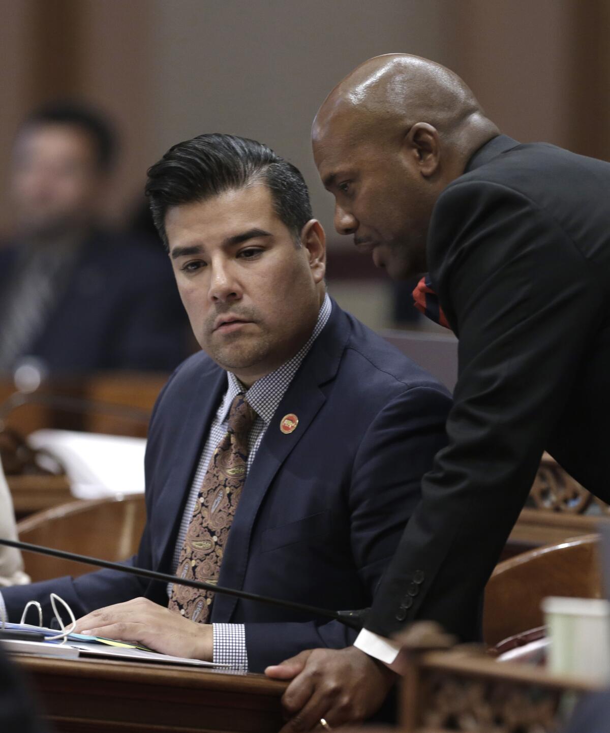 El senador demócrata local de California, Ricardo Lara, de Bell Gardens, a la izquierda, conversa con el asembleísta Mike Gipson, demócrata de Carson, en el Capitolio estatal en Sacramento, el viernes 4 de septiembre de 2015. Lara desistió de sus intentos en busca de una dispensa federal para que en California se permita a las personas que vivan sin permiso en el país comprar una cobertura privada sin subsidio mediante Covered California, un sitio en el que individuos, familias y pequeñas empresas pueden obtener un seguro de salud de calidad y bajo costo.