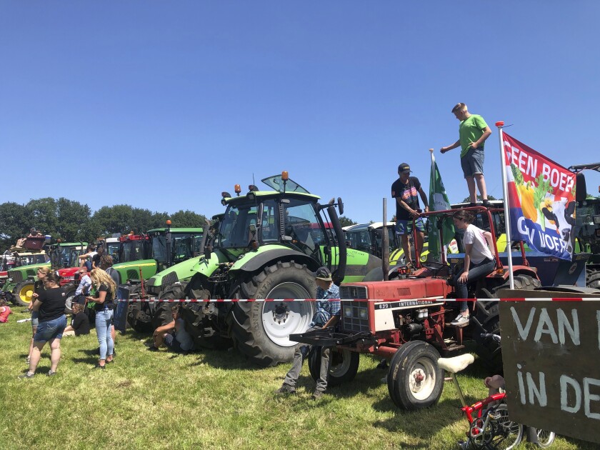 Dutch farmers protesting against the government’s plans to reduce emissions of nitrogen oxide and ammonia gather for a demonstration at Stroe, Netherlands, Wednesday, June 22, 2022. Thousands of farmers drove their tractors along roads and highways across the Netherlands, heading for a mass protest against the Dutch government’s plans to rein in emissions of nitrogen oxide and ammonia. (AP Photo/Aleksandar Furtula)