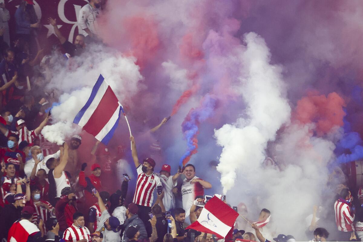 Soccer fans release color smokes during the second half of a f 