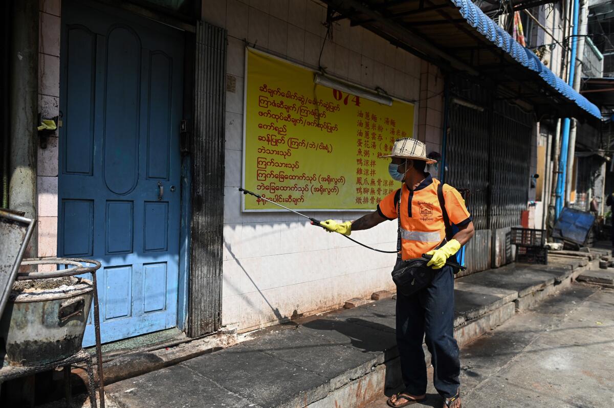 A city worker disinfects a street as a preventive measure against the coronavirus in Yangon, Myanmar.