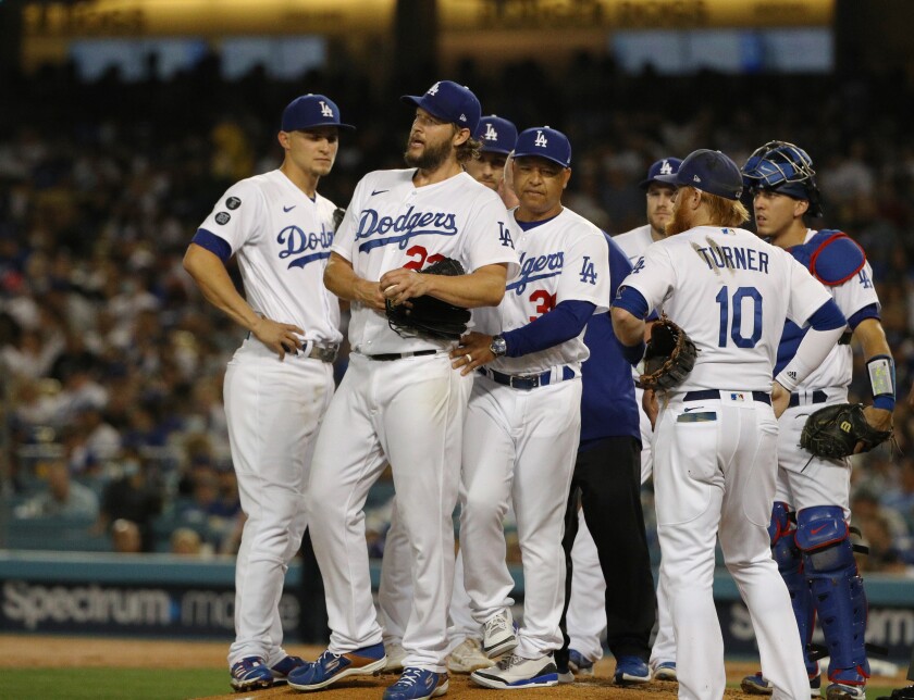 Clayton Kershaw, second from left, is removed from the game Friday after injuring his left arm.