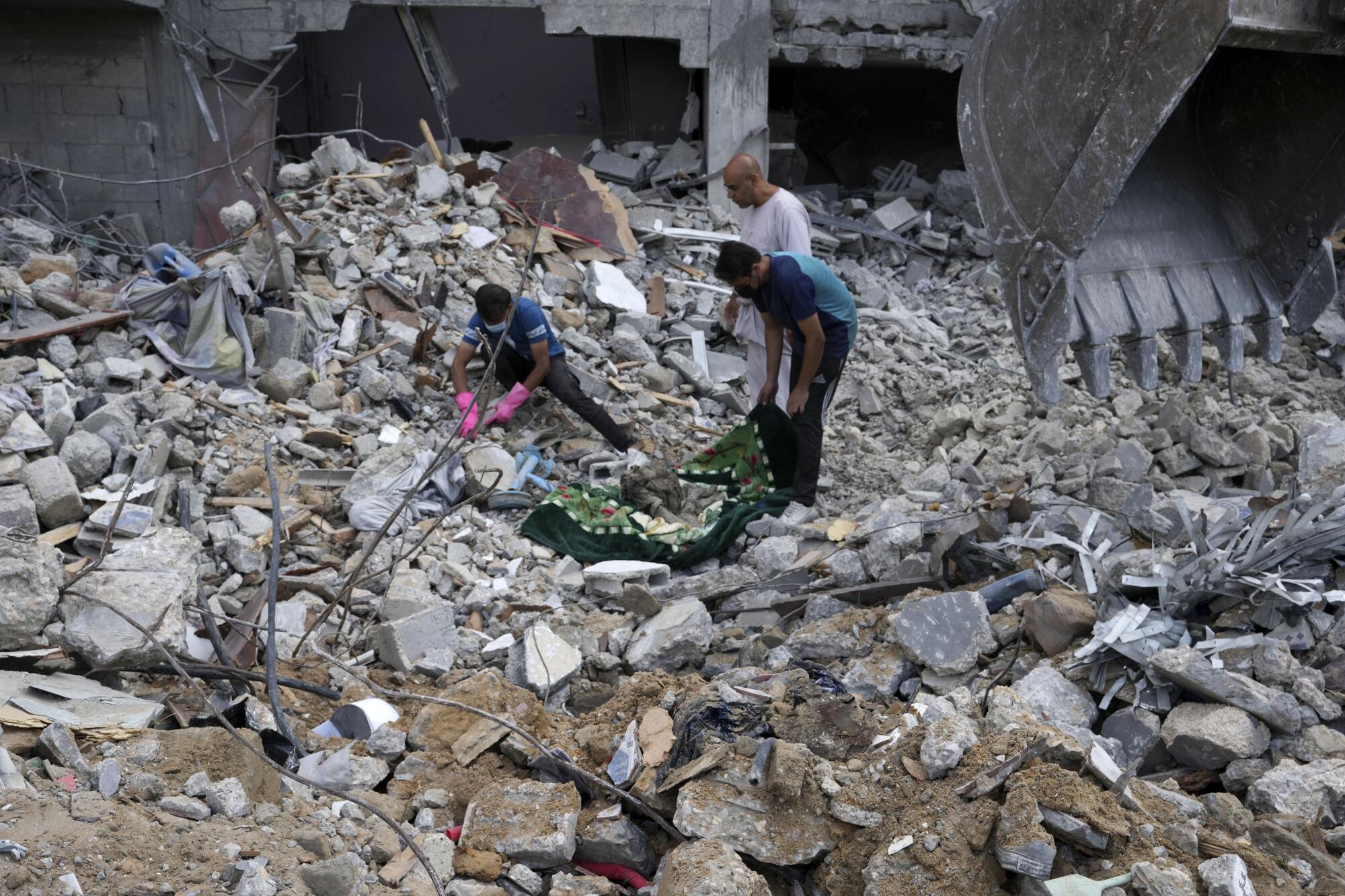 People recovering bodies from rubble in Gaza